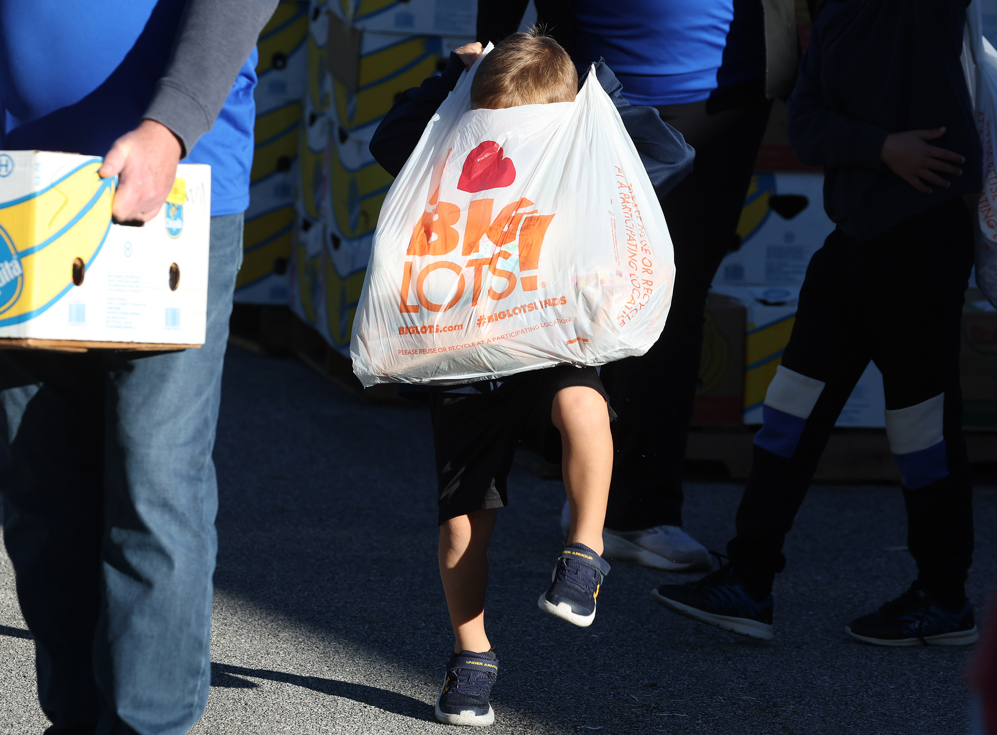 Benjamin Jungwirth, 5, struggles to lift a big bag of...