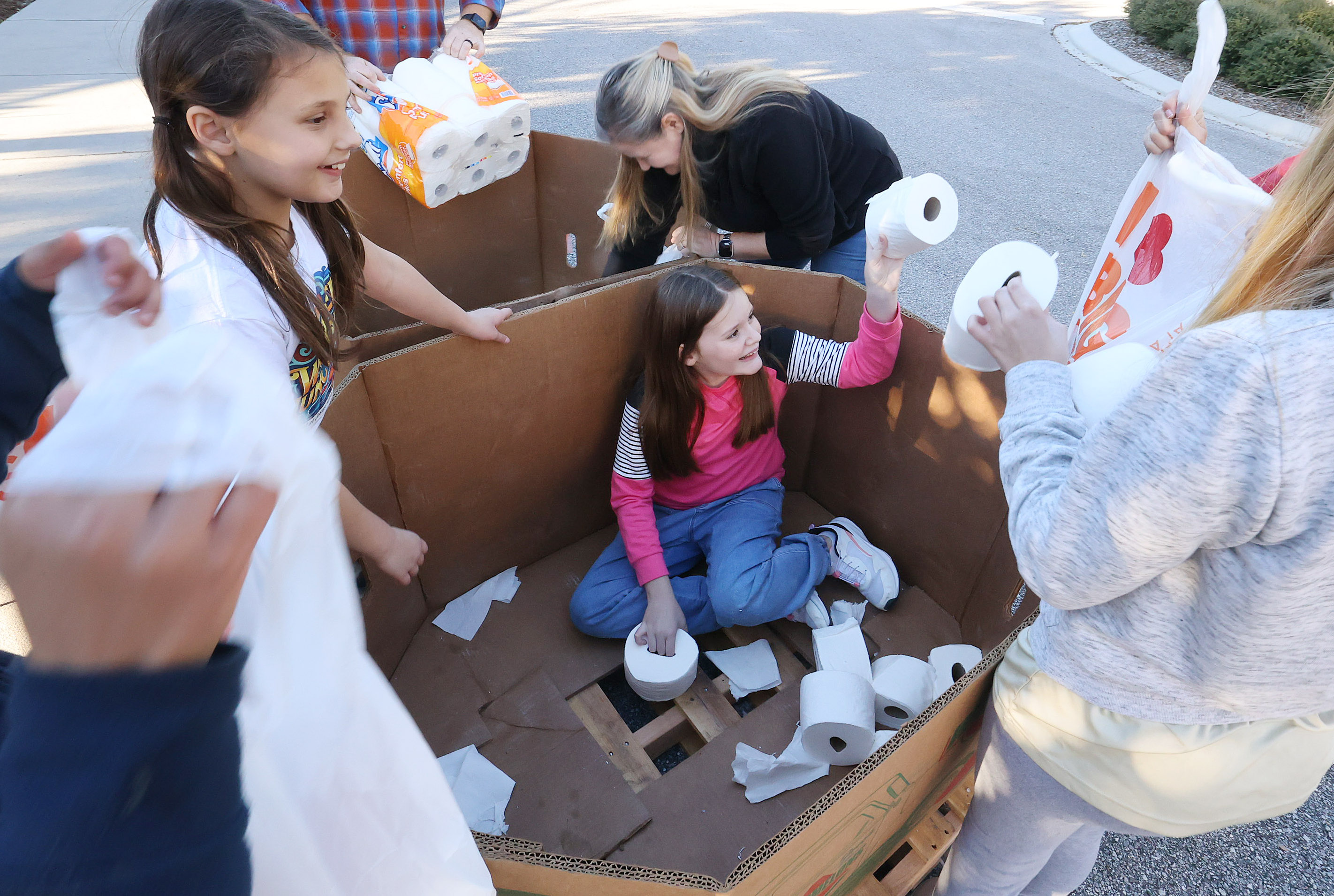 Chloe Fears (middle) distributes toilet paper to other volunteers at...