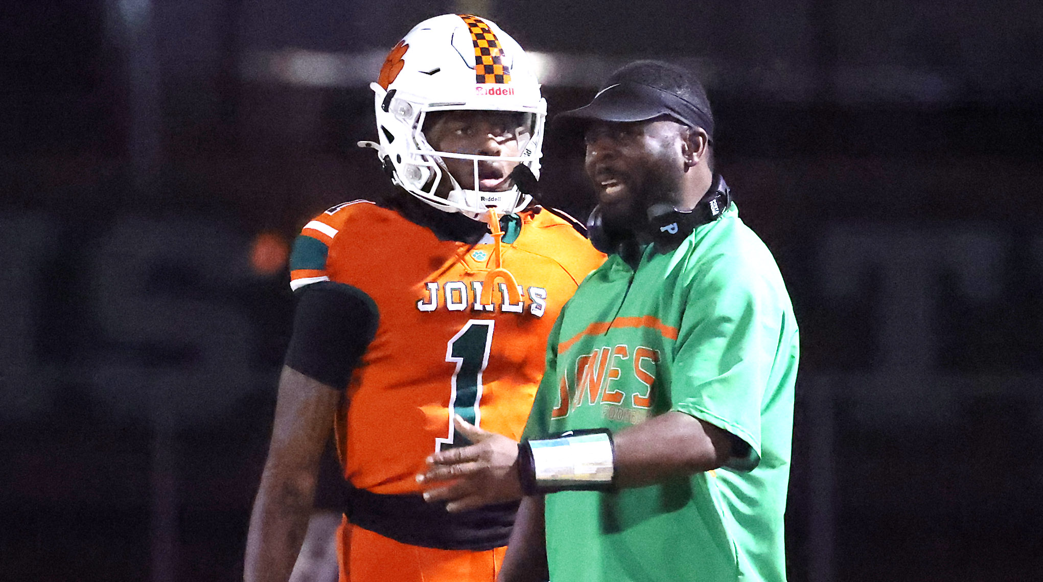 Jones High coach Elijah Williams coaches quarterback Dereon Coleman (1)...