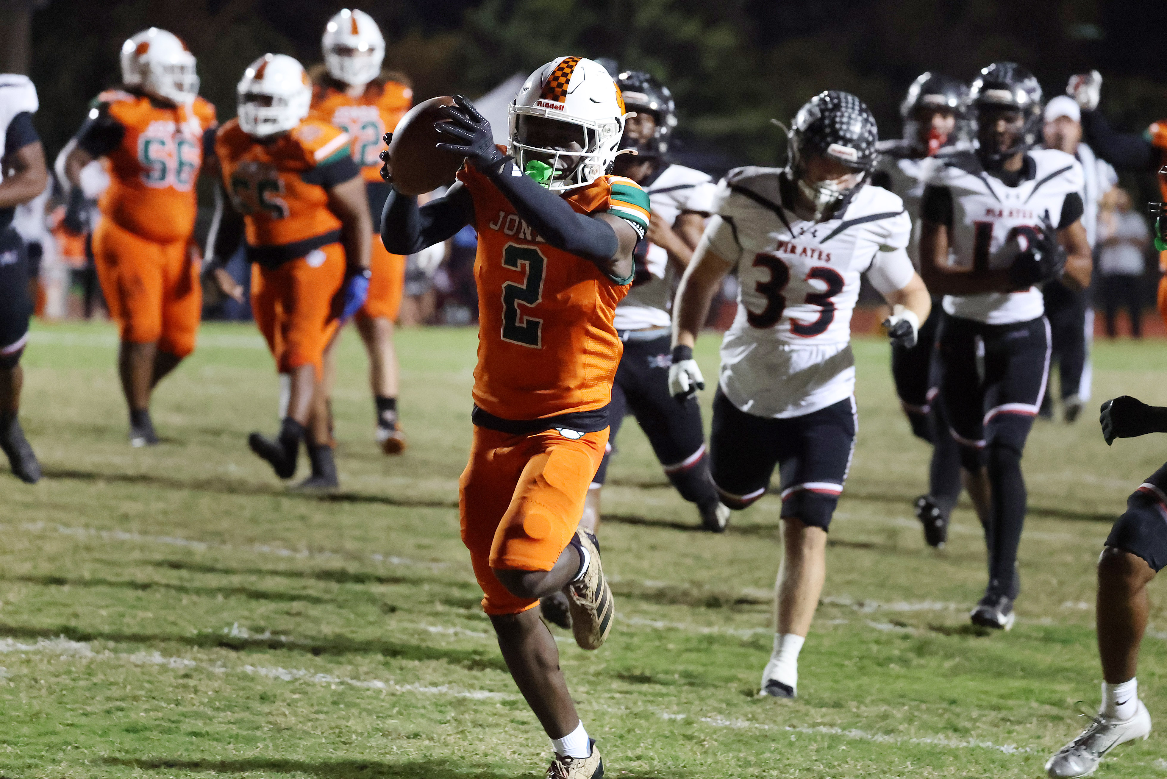 Jones High receiver Larry Miles holds the ball aloft as...