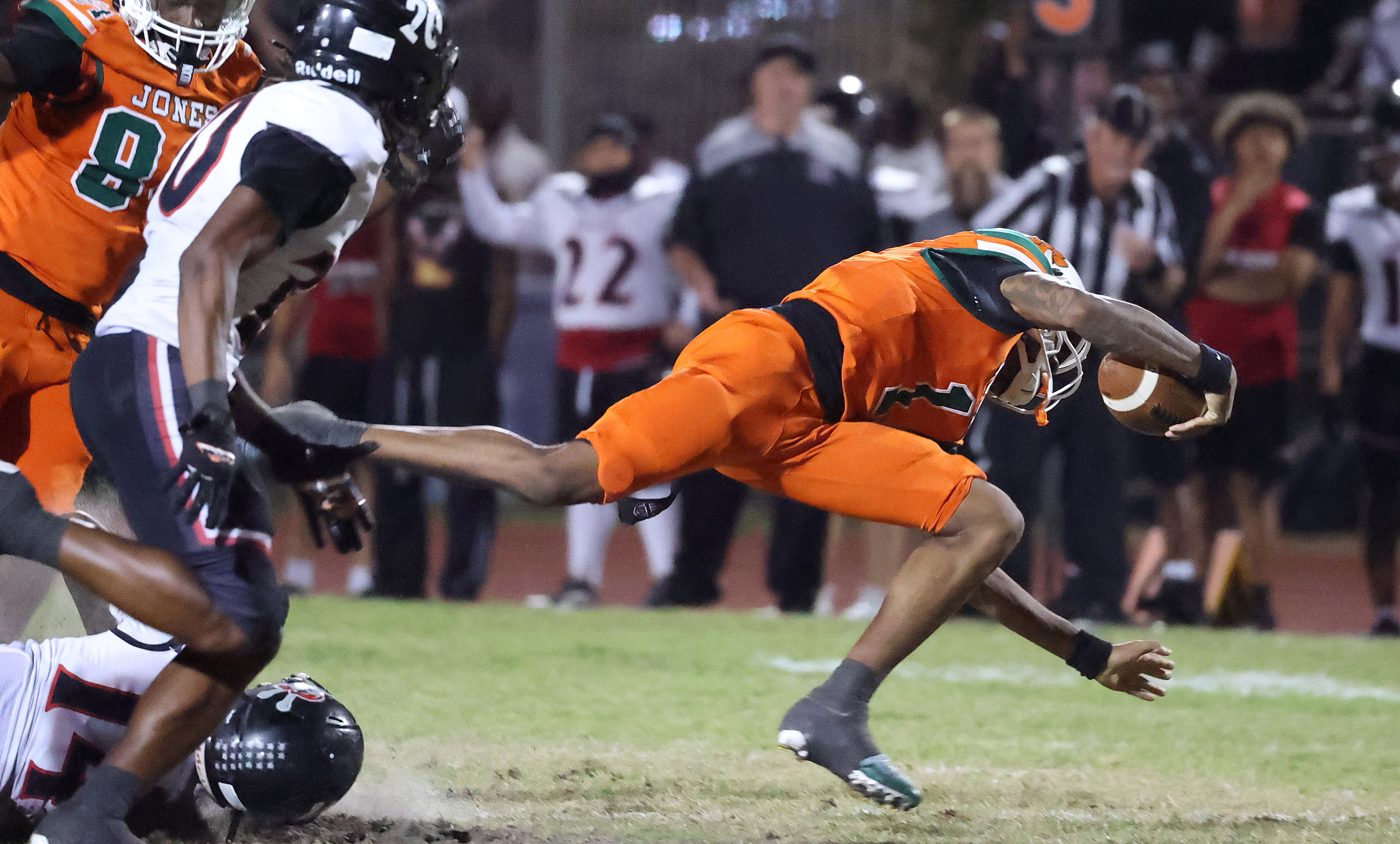 Jones High quarterback Dereon Coleman (1) leaps for extra yardage...