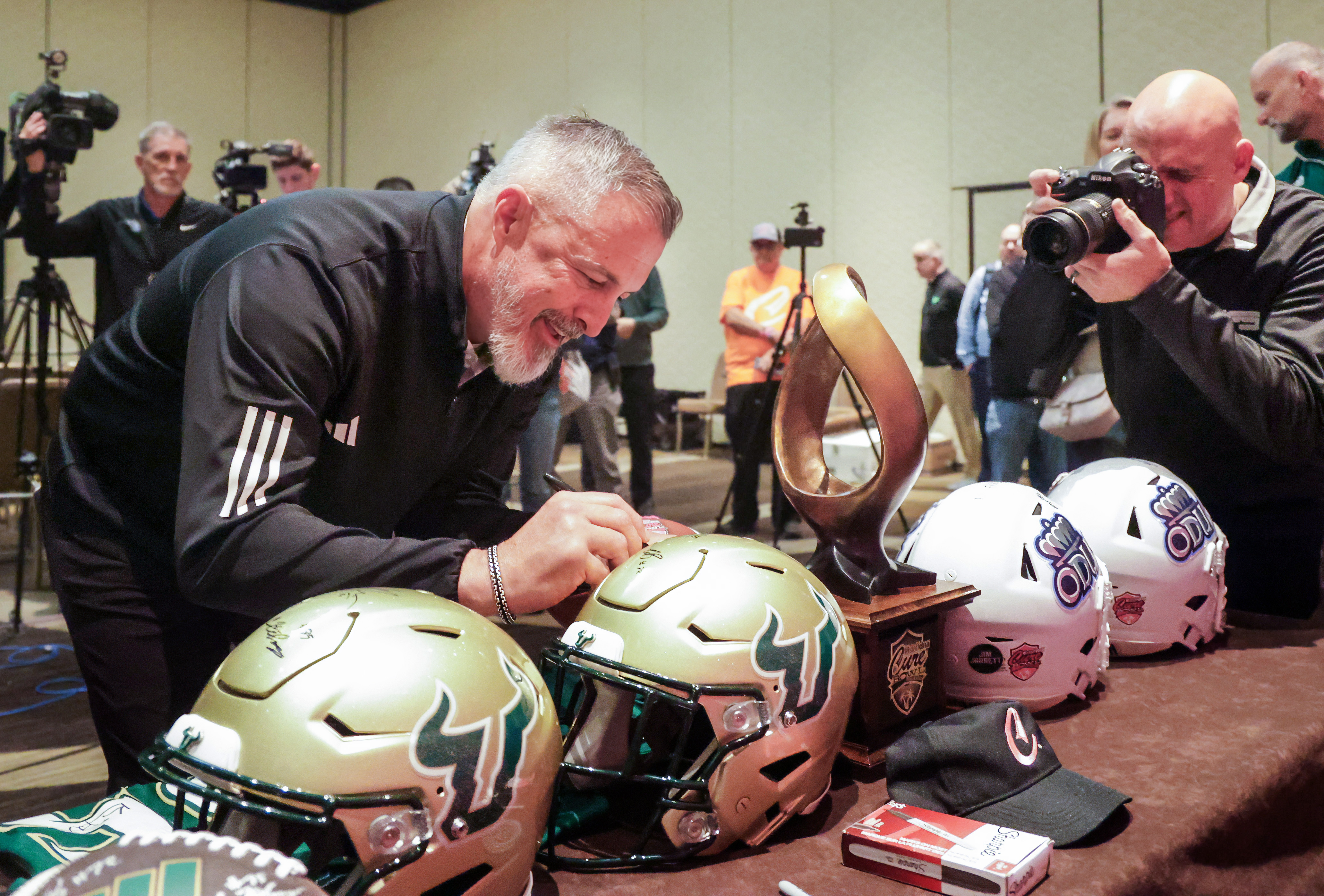 University of South Florida interim head coach Kevin Patrick signs...