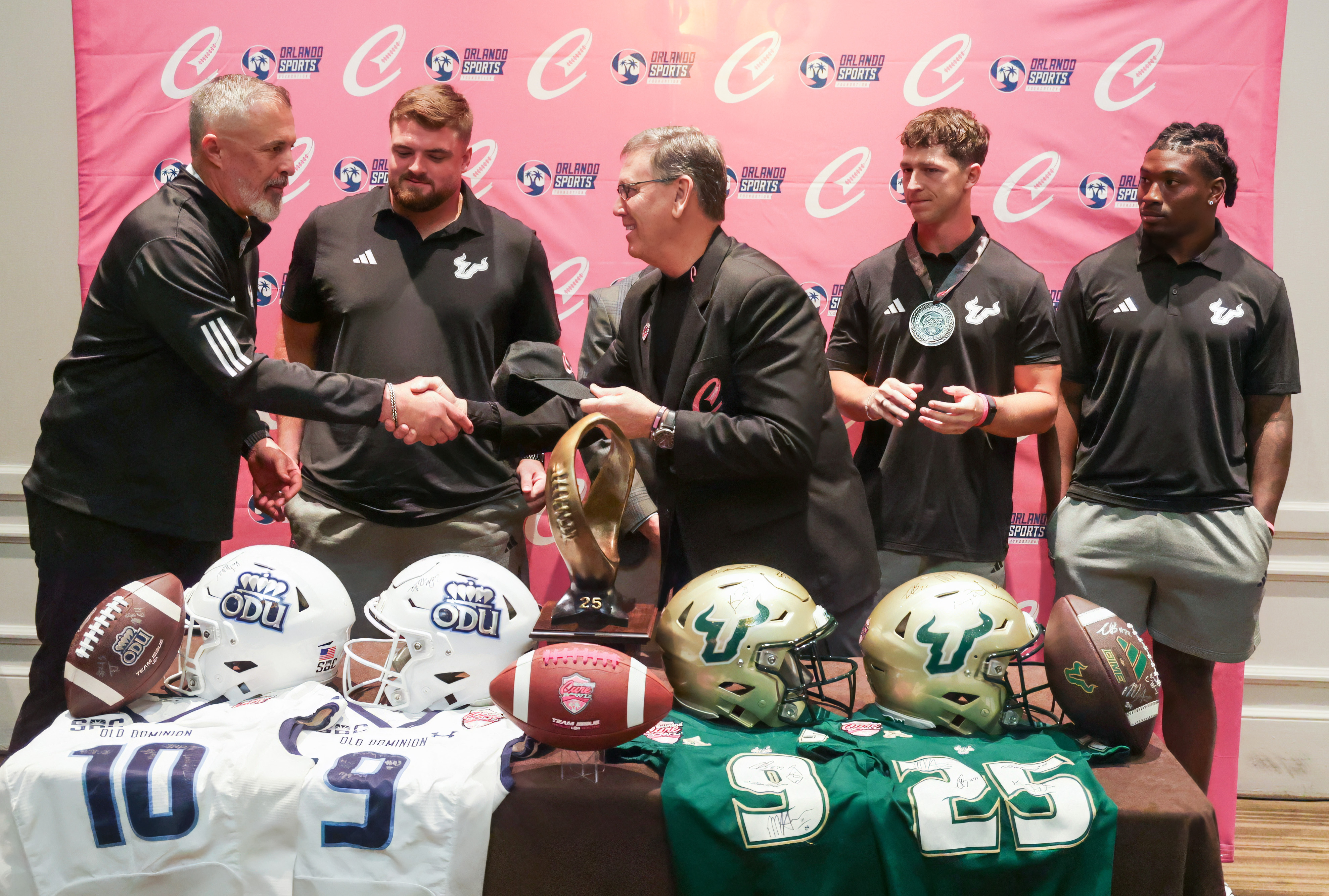 Alan Gooch, CEO of the Orlando Sports Foundation, right, presents...