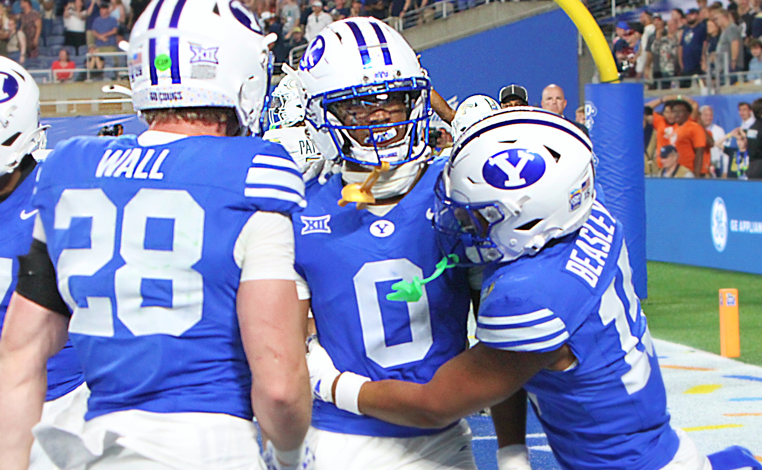 BYU defensive back Evan Johnson is mobbed by teammates after...
