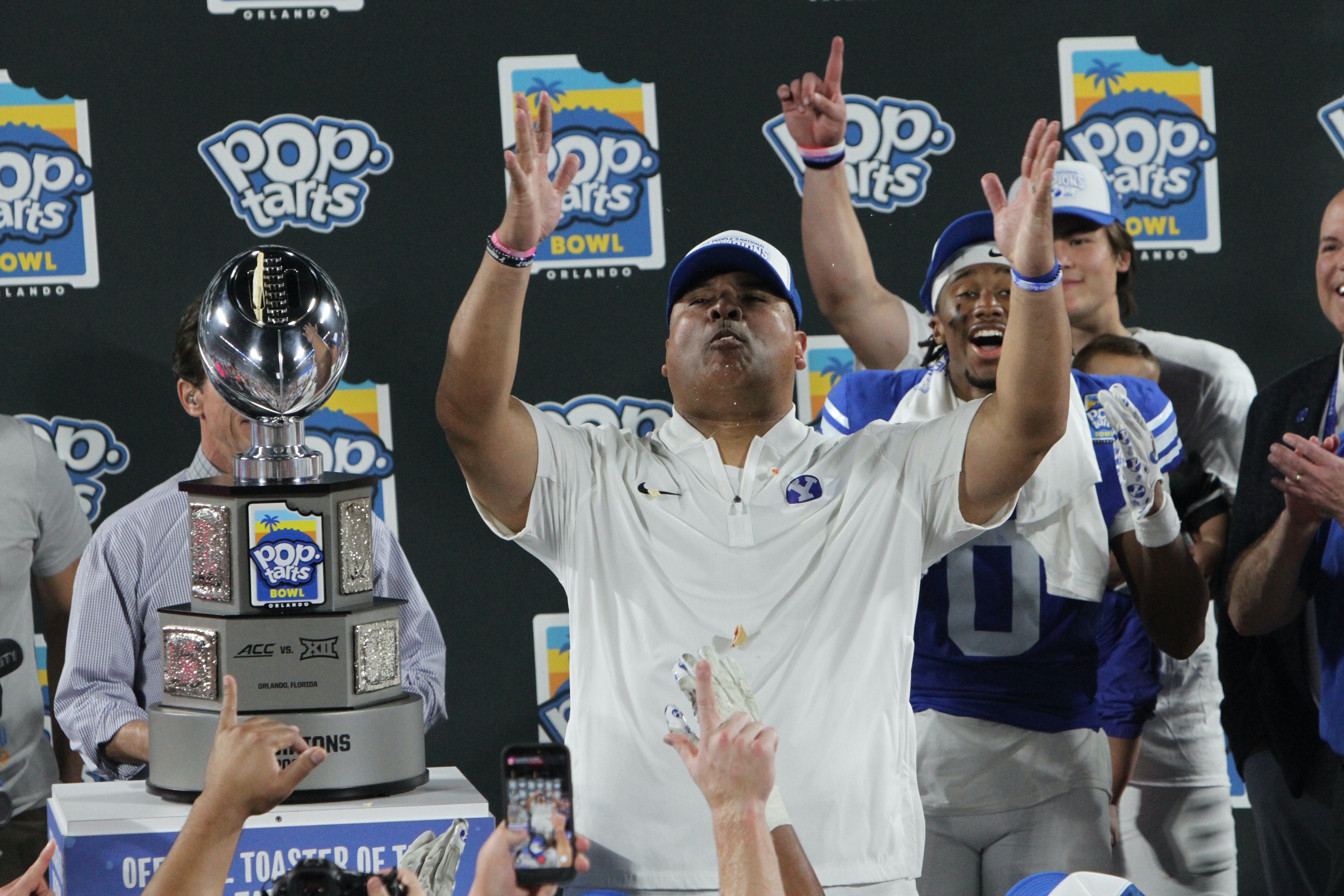 BYU coach Kalani Sitake celebrates with the Pop-Tarts Bowl trophy...