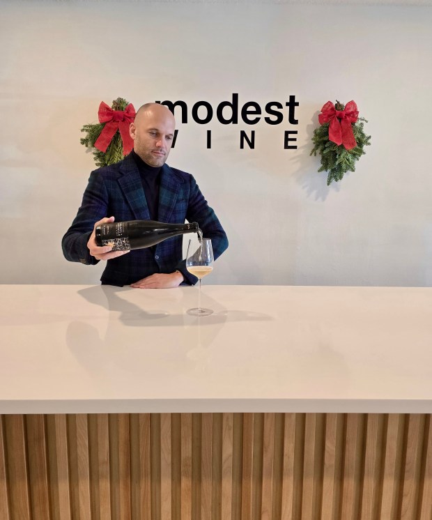 Kyle Ridington of Modest Wine pours a bottle of Champagne Gounel + Lassalle, Les Agneaux, Premier Cru at his Winter Park wine shop/bar. (Photo courtesy Modest Wine)