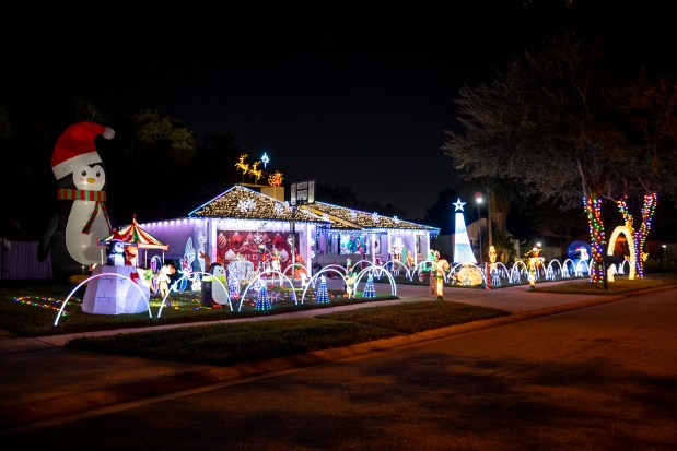 The Lights of Newbridge Lane features a towering penguin, lights on the roof, arches and a tree synchronized to music at 1424 Newbridge Lane in Orlando on Dec. 10, 2025. (Patrick Connolly/Orlando Sentinel)