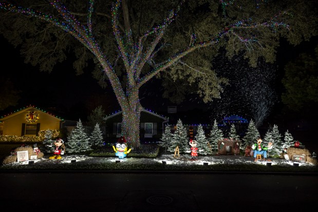 The Valle family in Maitland presents a display with Disney characters that sing and a singular Minion, plus snow, at 2216 Chippewa Trail in Maitland on Dec. 10, 2025. (Patrick Connolly/Orlando Sentinel)