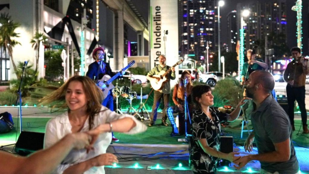 A group of people dancing in an outdoor venue .