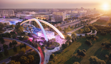 Rendering of the Gas Plant District Gateway at 13th Street with modern buildings, palm trees, and a pedestrian-friendly plaza at sunset.