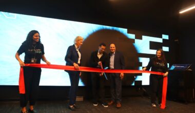 Leaders and team members cut a ribbon during the launch of The Digital Suite Tampa at Embarc Collective.