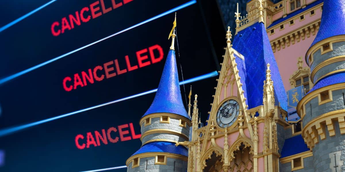A digital board displays the word "CANCELLED" in red multiple times next to the spires of Cinderella Castle at a Disney World theme park at the airports cancel flights and shrink down access to the theme parks thanks to the government shutdown.