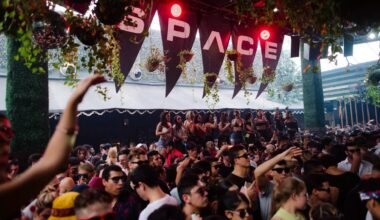 Photo of a group of people dancing at a venue under a sign that reads Space.