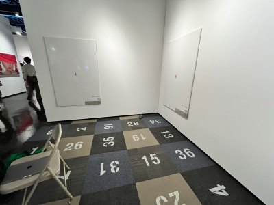 View of a gallery booth with numbers on the floor.