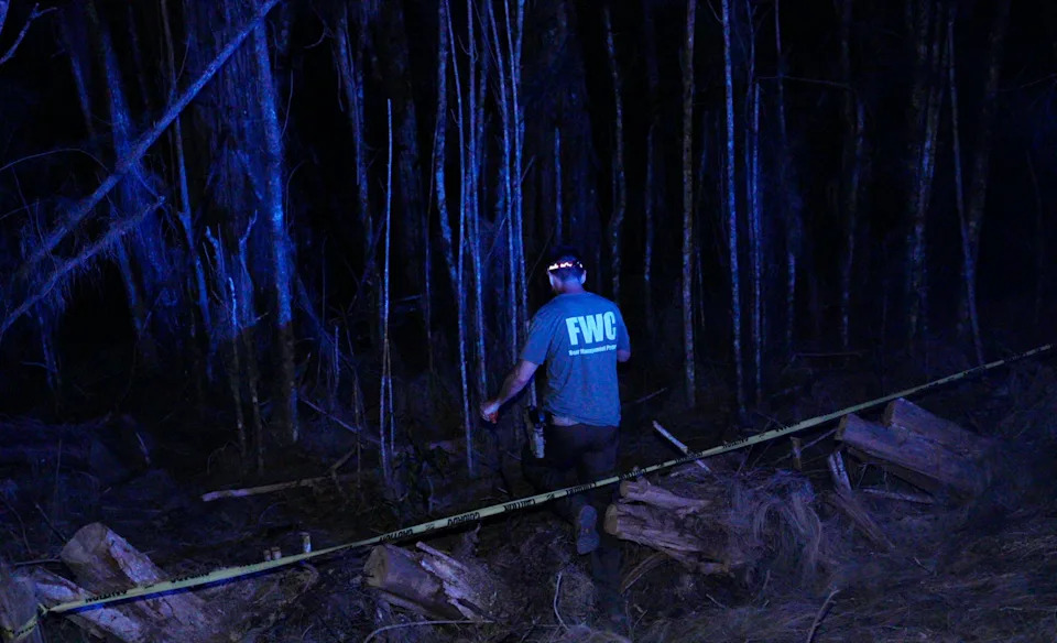 Members of the FWC work to remove a dead bear near the home where a man and dog were found dead after a bear attack in Jerome in Collier County on May 5. Multiple shots were heard.