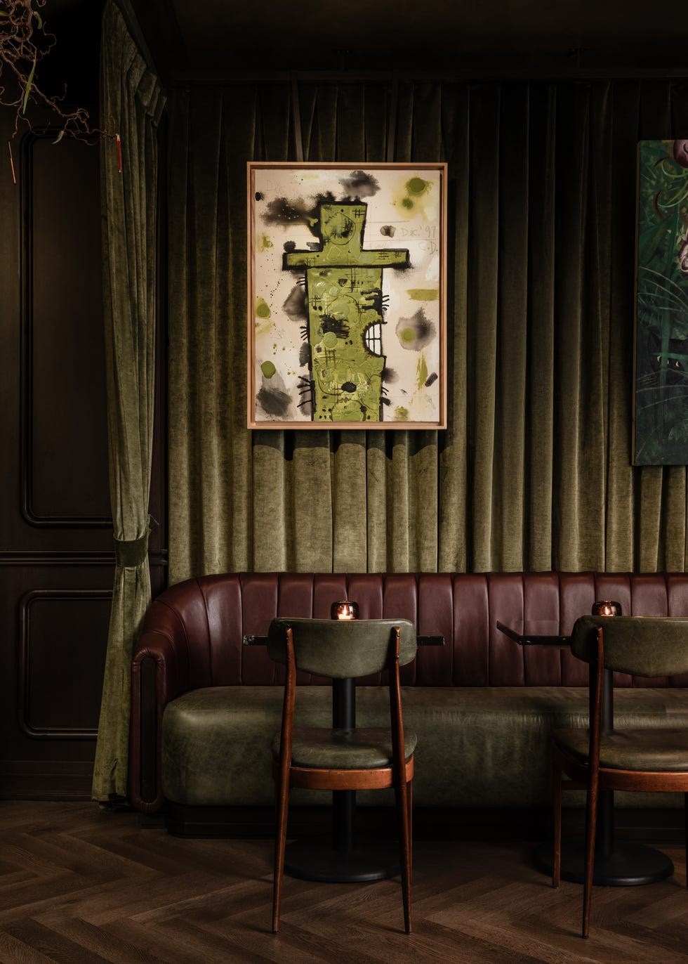 Artwork on a wall in a lounge setting with a brown leather sofa and wooden tables. Artwork on a wall in a lounge setting with a brown leather sofa and wooden tables.