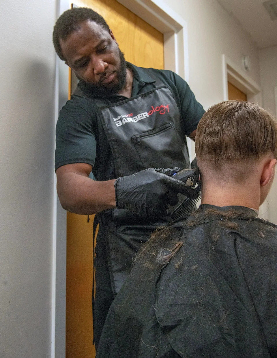 Carmello Colley of VIP Barber Shop gives free haircuts during the Bliss Summer Bash for Hope at Curie House on Aug. 2. The  luau-style celebration was designed to provide a safe, uplifting space for youth currently living in a homeless shelter. The event included free haircuts, free food, music, Hula Hoop contest, limbo and more.