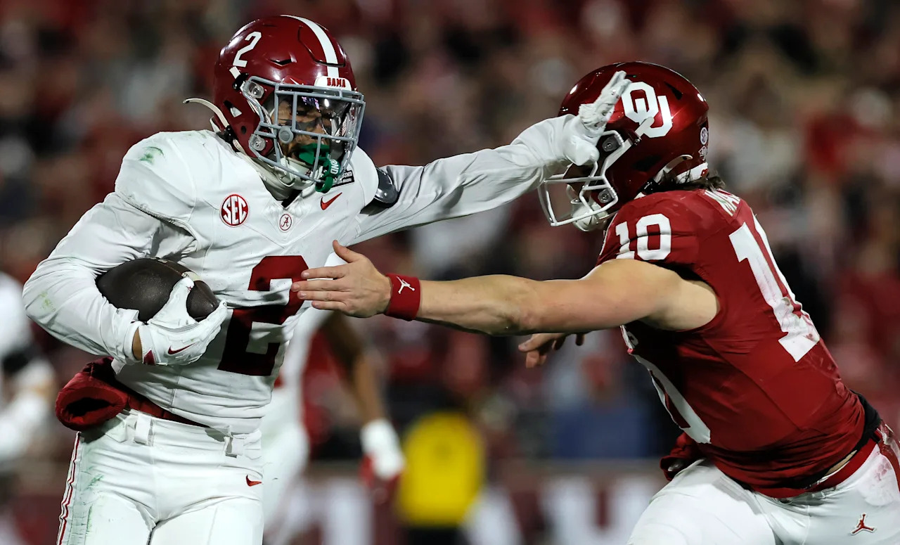 NORMAN, OKLAHOMA - DECEMBER 19: Zabien Brown #2 of the Alabama Crimson Tide stiff arms John Mateer #10 of the Oklahoma Sooners during the second quarter during 2025 College Football Playoff First Round Game at Gaylord Family Oklahoma Memorial Stadium on December 19, 2025 in Norman, Oklahoma.  (Photo by Brian Bahr/Getty Images)