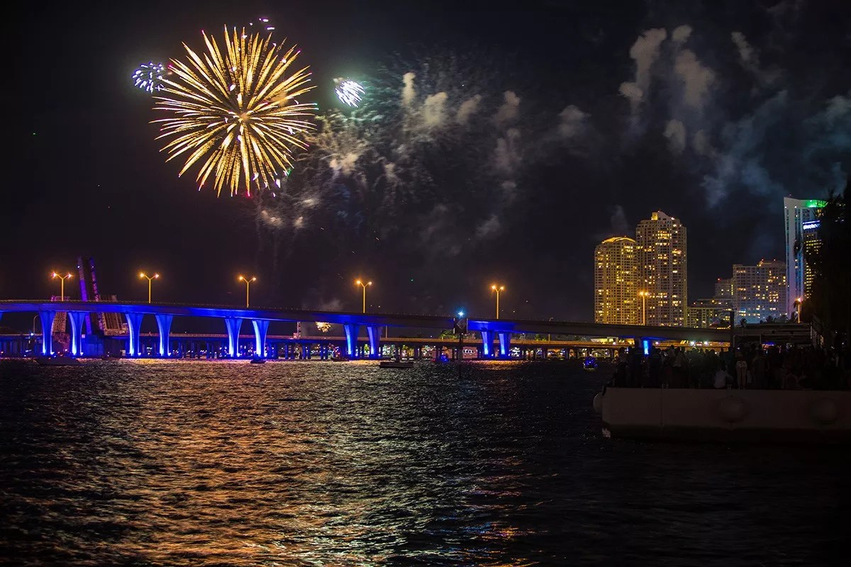 photo of fireworks over a Miami bridge and ocean at night