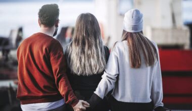 photo of a man and woman holding hands behind another woman