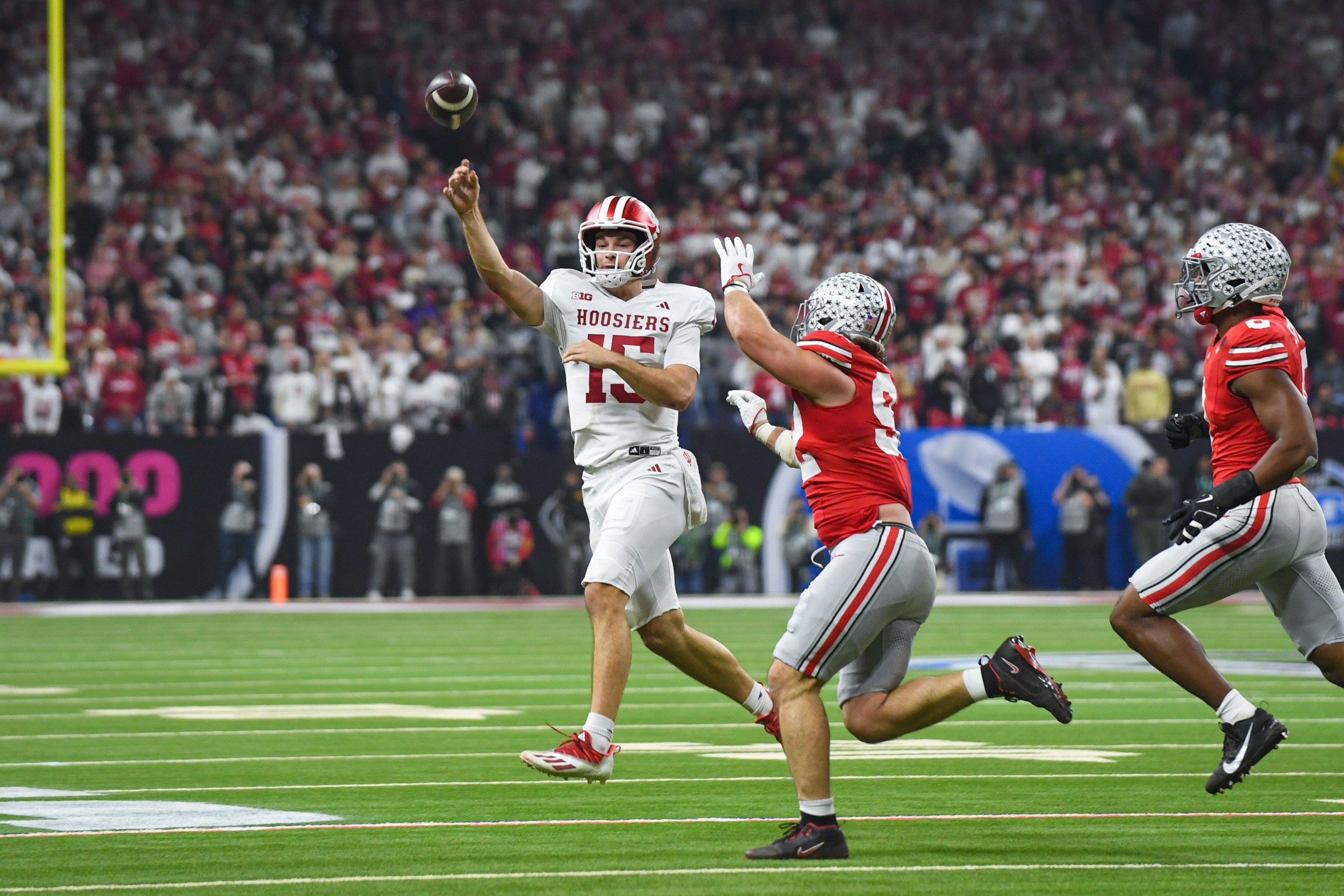 INDIANAPOLIS, INDIANA - DECEMBER 06: Fernando Mendoza #15 of the Indiana Hoosiers attempts to throw a pass against Caden Curry #92 and Sonny Styles #0 of the Ohio State Buckeyes during the first half of the Big Ten Championship game at Lucas Oil Stadium on December 06, 2025 in Indianapolis, Indiana. (Photo by Aaron J. Thornton/Getty Images)