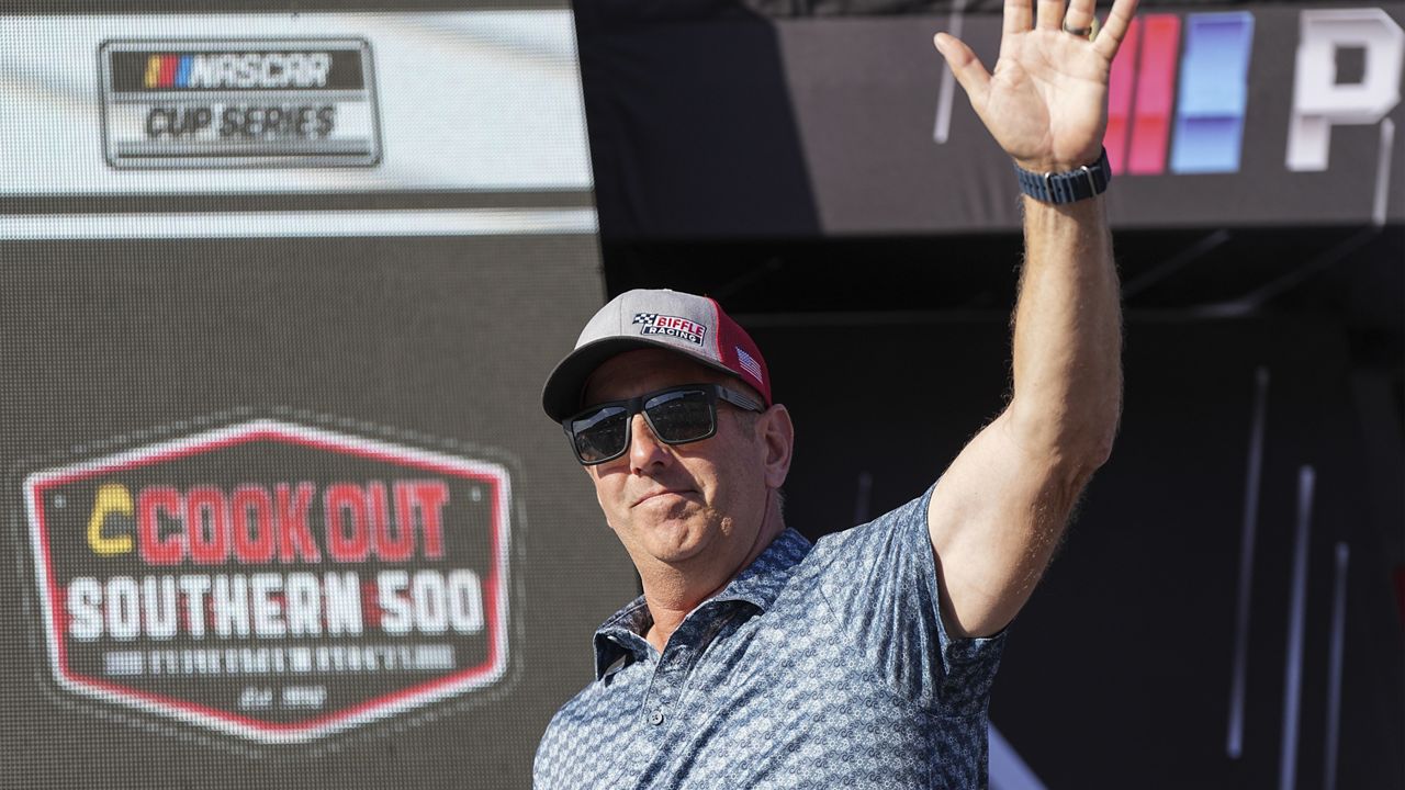 Former driver Greg Biffle waves to fans prior to a NASCAR Cup Series auto race at Darlington Raceway, Sunday, Aug. 31, 2025, in Darlington, S.C. (AP Photo/Matt Kelley)