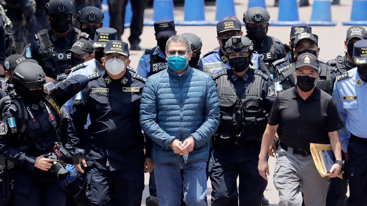 Police special forces escort the former Honduran president during his transfer for extradition proceedings in Tegucigalpa.