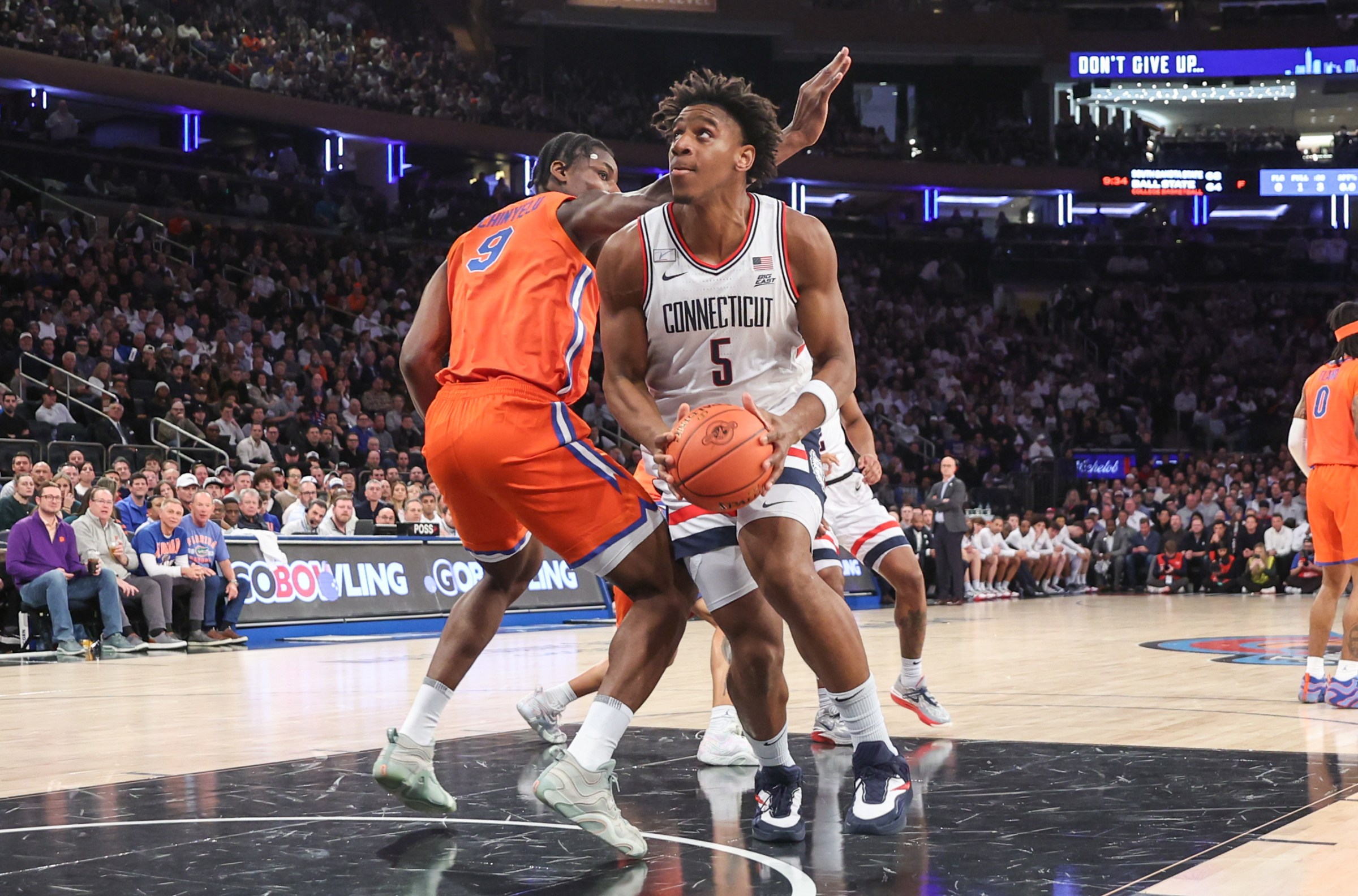 Dec 9, 2025; New York, New York, USA; UConn Huskies forward Tarris Reed Jr. (5) drives past Florida Gators center Rueben Chinyelu (9) in the first half at Madison Square Garden. Mandatory Credit: Wendell Cruz-Imagn Images