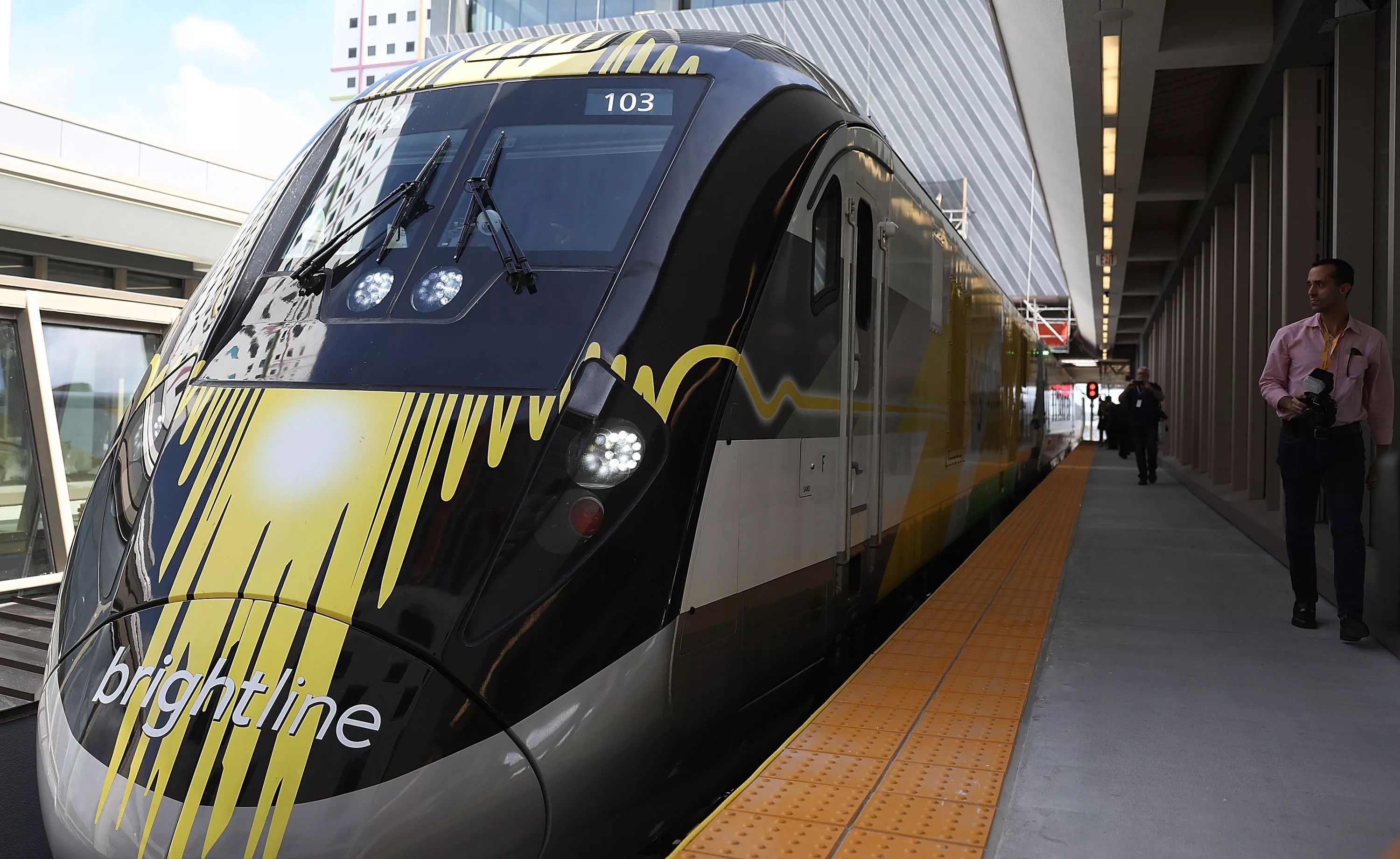 A brightline train sits on the platform