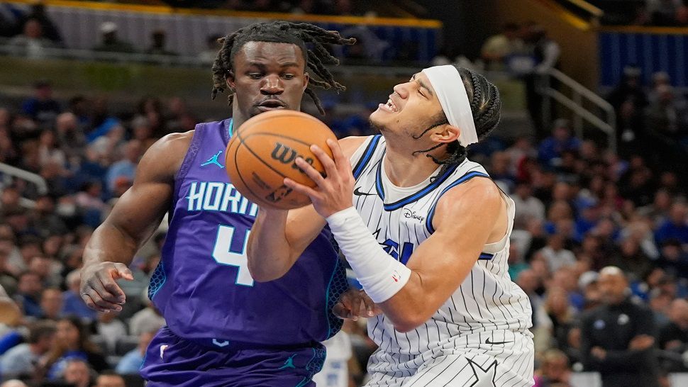 Orlando Magic guard Anthony Black, right, looks for a shot against Charlotte Hornets guard Sion James (4) during the first half of an NBA basketball game, Friday, Dec. 26, 2025, in Orlando, Fla. (AP Photo/John Raoux)