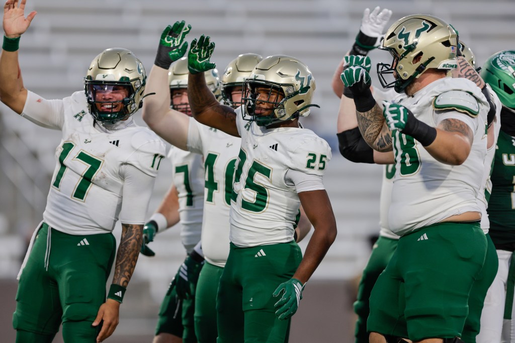 Nykahi Davenport #25 of the South Florida Bulls celebrates a rushing touchdown with teammates against the UAB Blazers.