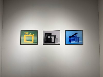 Three highly saturated photographs hang on a wall.