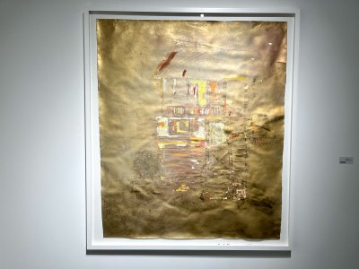 A gold painting with a ghostly depiction of a house.