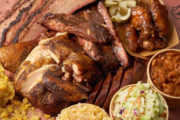 A platter of various meats and sides including brisket, ribs, coleslaw and beans at Drinking Pig BBQ, which will expand into Delray Beach's seven-acre Sundy Village project in late 2026. (Drinking Pig BBQ / Courtesy)