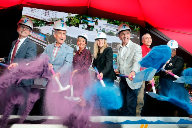 Broward Health President and CEO Shane Strum, from left, Fort Lauderdale City Commissioner Steve Glassman, YMCA of South Florida President and CEO Sheryl Woods, YMCA of South Florida Board Chair Marilyn Pascual, Fort Lauderdale Mayor Dean Trantalis and Fort Lauderdale city commissioners Ben Sorensen and Pamela Beasley-Pittman shovel colored sand during a ceremonial groundbreaking for a new YMCA Family Center at Holiday Park in Fort Lauderdale on Monday, Dec. 9, 2025. (Amy Beth Bennett / South Florida Sun Sentinel)