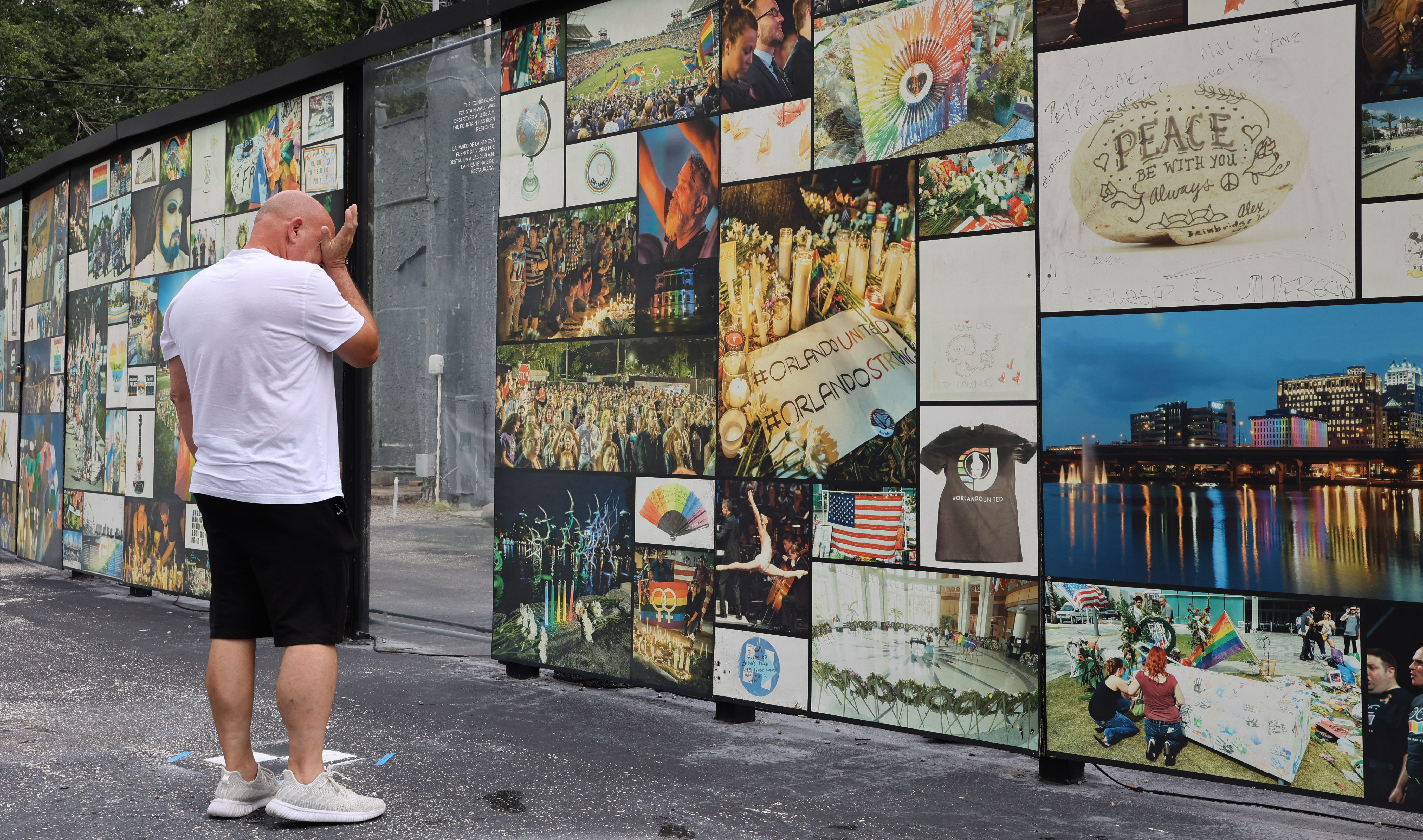 Luis Santiago wipes his eyes while looking at the memorial...