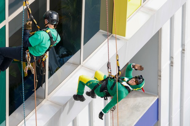 Alex "Fonzy" Ildefonso, from Orange County Fire Rescue, rappels down the side of AdventHealth for Children, interacting with children and their families through the windows on Thursday, December 18, 2025. (Rich Pope/Orlando Sentinel)
