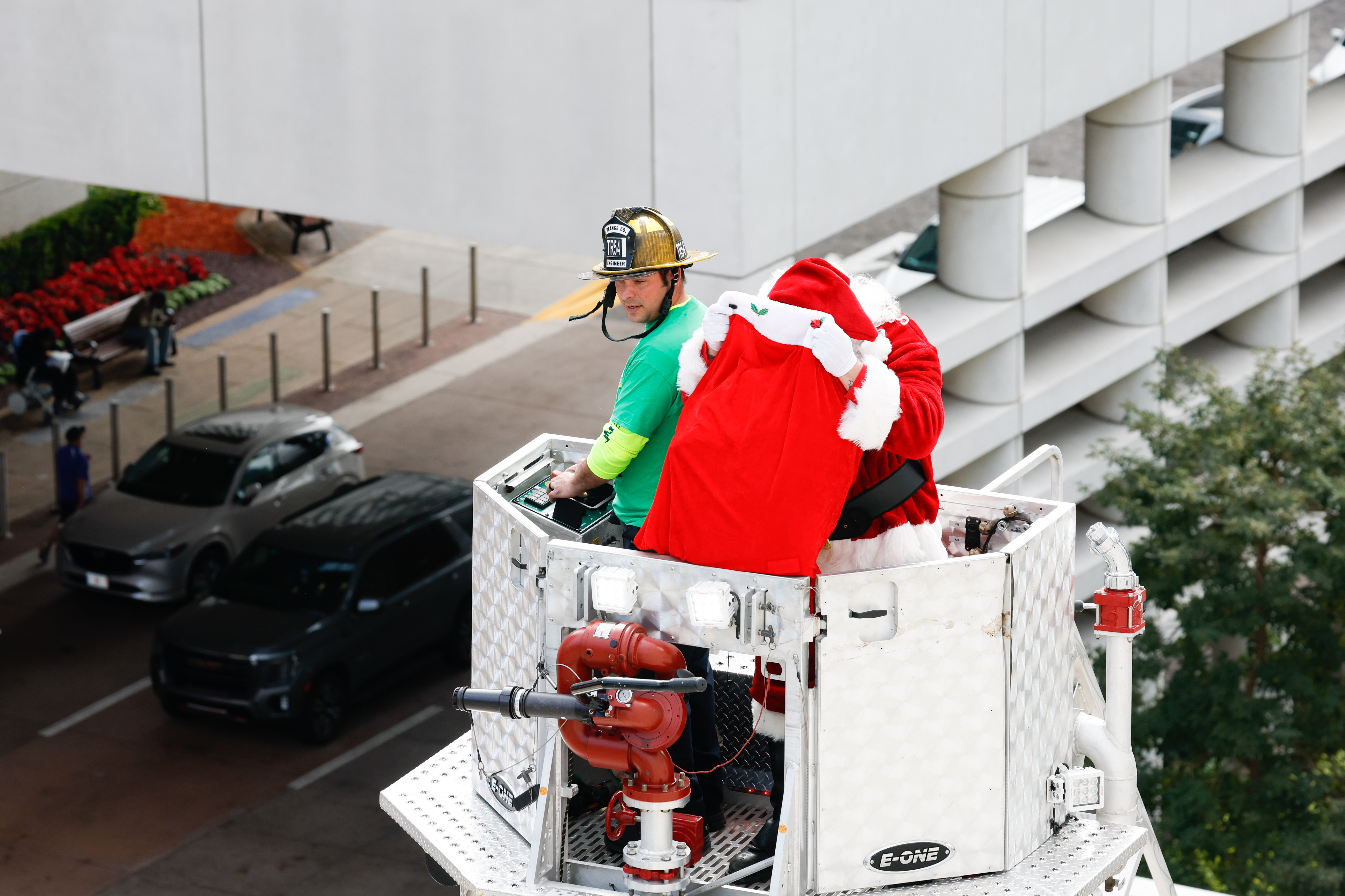 Santa goes through his sack from high above in a ladder truck as Orange County Fire Rescue and the Orlando Fire Department rappel down the side of AdventHealth for Children, interacting with children and their families through the windows on Thursday, December 18, 2025.(Rich Pope/Orlando Sentinel)