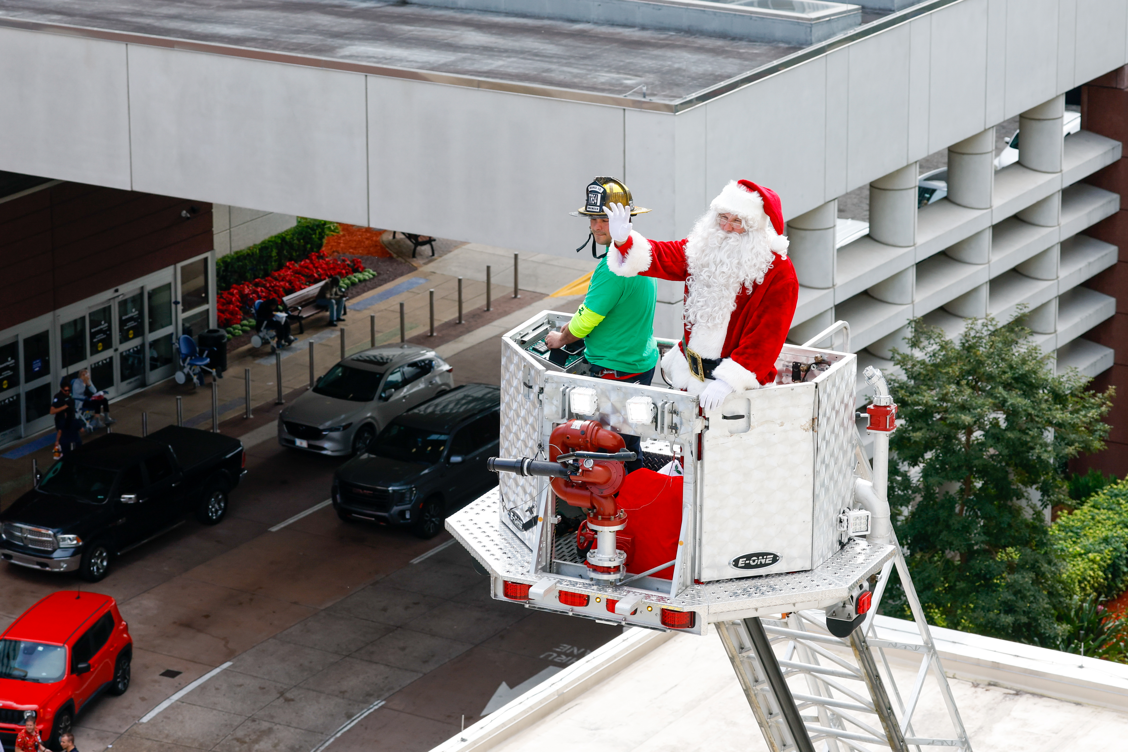 Santa gives a wave from high above in a ladder truck as Orange County Fire Rescue and the Orlando Fire Department rappel down the side of AdventHealth for Children, interacting with children and their families through the windows on Thursday, December 18, 2025.(Rich Pope/Orlando Sentinel)