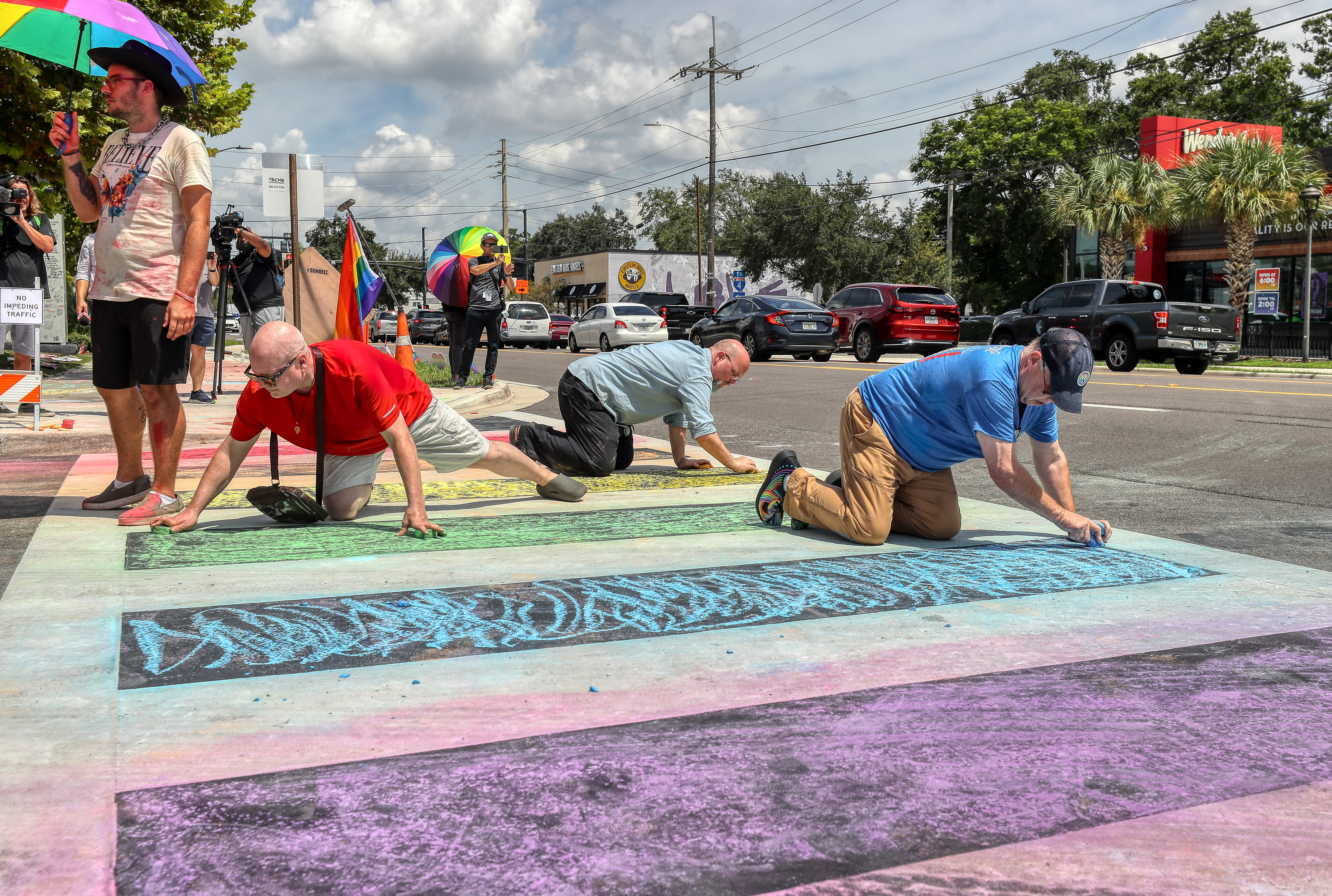 Protestors use chalk to re-color the pedestrian crosswalk. FDOT placed...