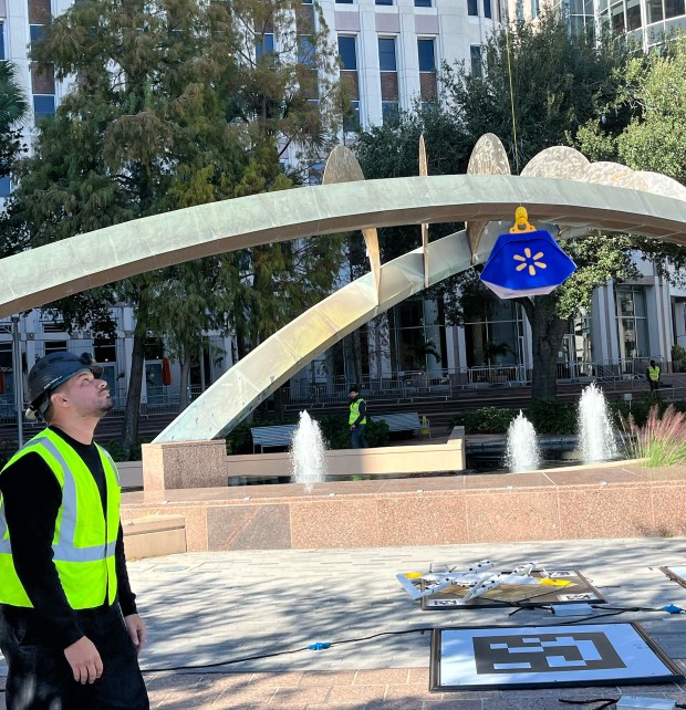Wing Flight Operations Support Coordinator, Joshua Lorenzo Simonetti, works with a Wing drone at a demonstration outside City Hall on Tuesday, December 16, 2025. (Michael Cuglietta/Orlando Sentinel)