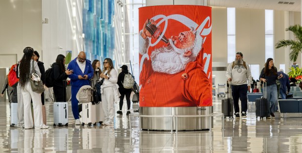 Santa with a soft-drink in a holiday advertisement in terminal C of the Orlando International Airport, on Wednesday, December 17, 2025. (Ricardo Ramirez Buxeda/Orlando Sentinel)