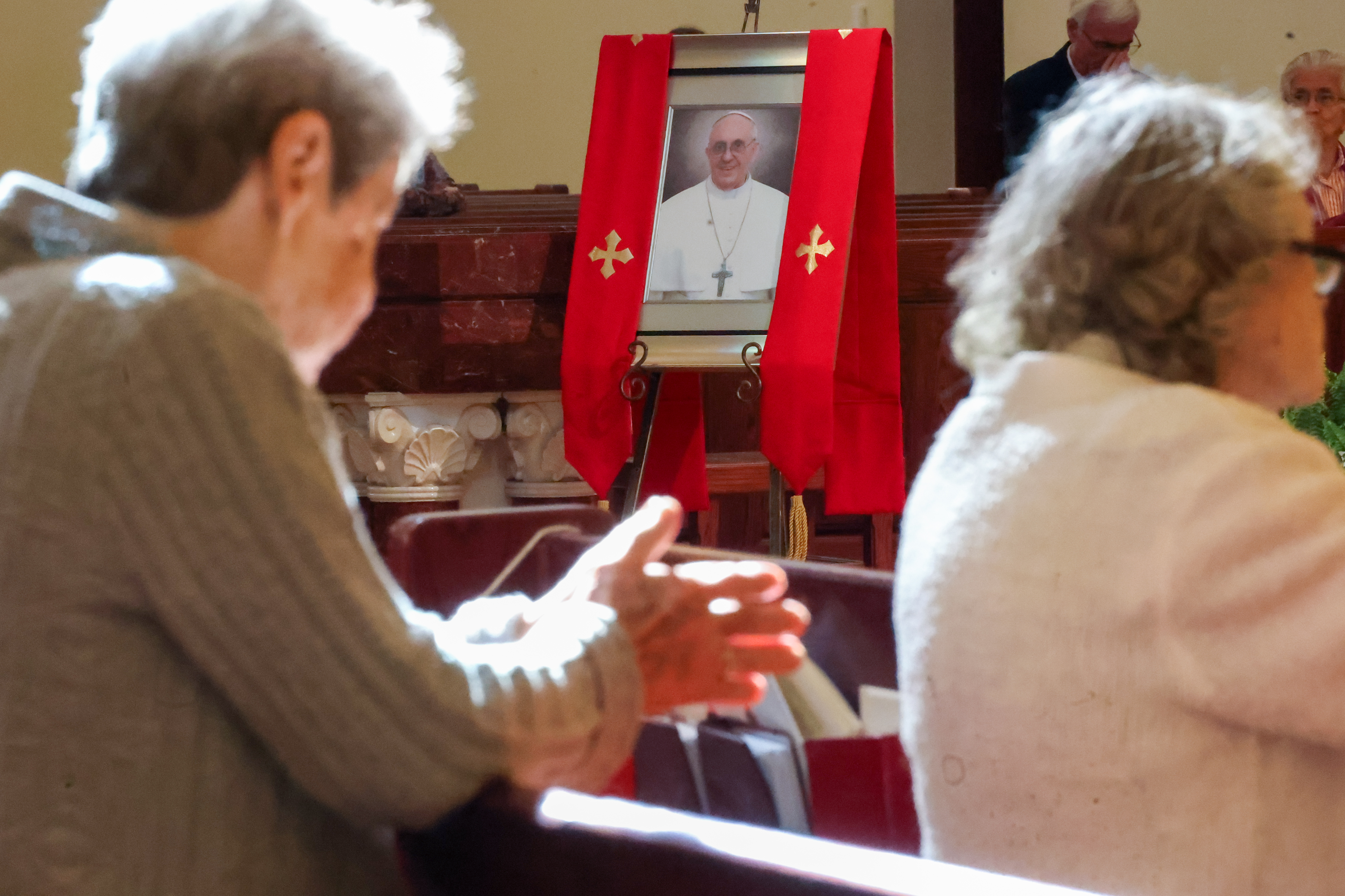 A picture of Pope Francis is displayed at St. James...