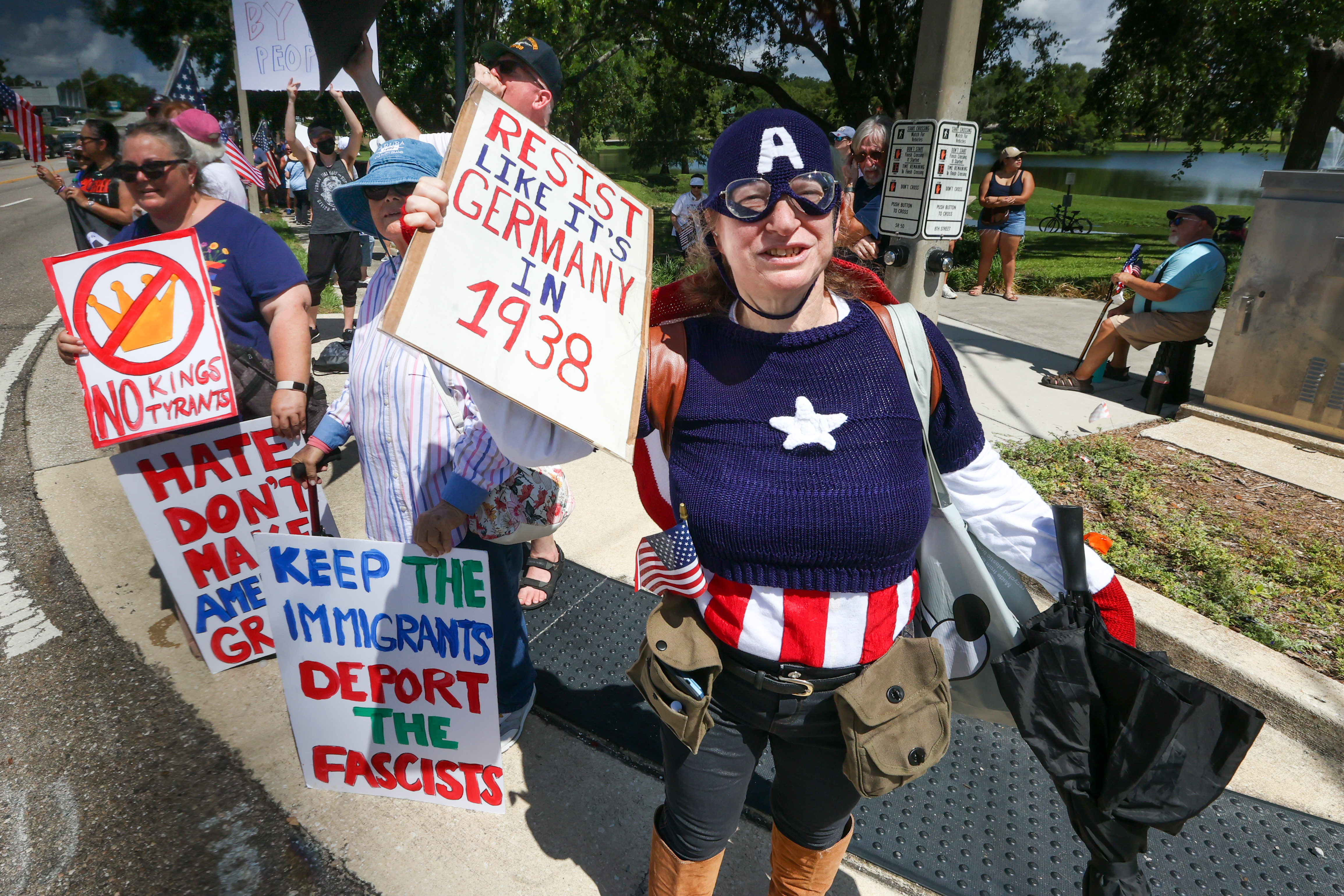 Individuals wave signs to traffic along Highway 50 in downtown...