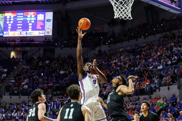Florida center Rueben Chinyelu (9) shoots the ball as he drives past Dartmouth forward Brandon Mitchell-Day (21) during the second half on Monday night in Gainesville. (AP Photo/Chris Watkins)
