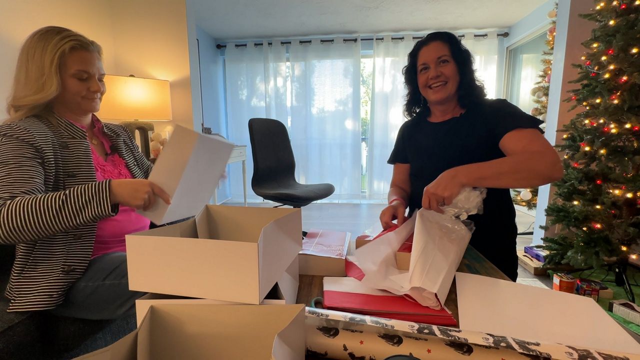 Britta Hammond and Olivia Hoegstrom wrap presents for Christmas. (Spectrum News)