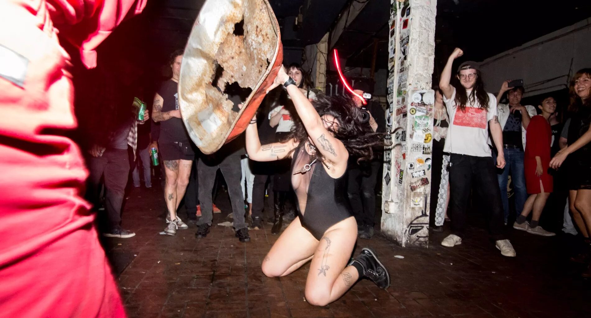 Photo of a woman on a stage pn her knees holding a metal structure