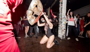 Photo of a woman on a stage pn her knees holding a metal structure