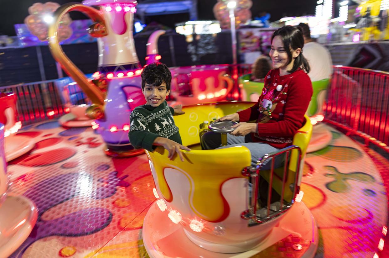 Enzo Ferreira, 7, and Ariadna Gallo enjoy a ride during the grand opening of Ripley's Believe It or Not! Christmas Park at Amelia Earhart Park on Thursday, Nov. 13, 2025, in Hialeah, Fla.