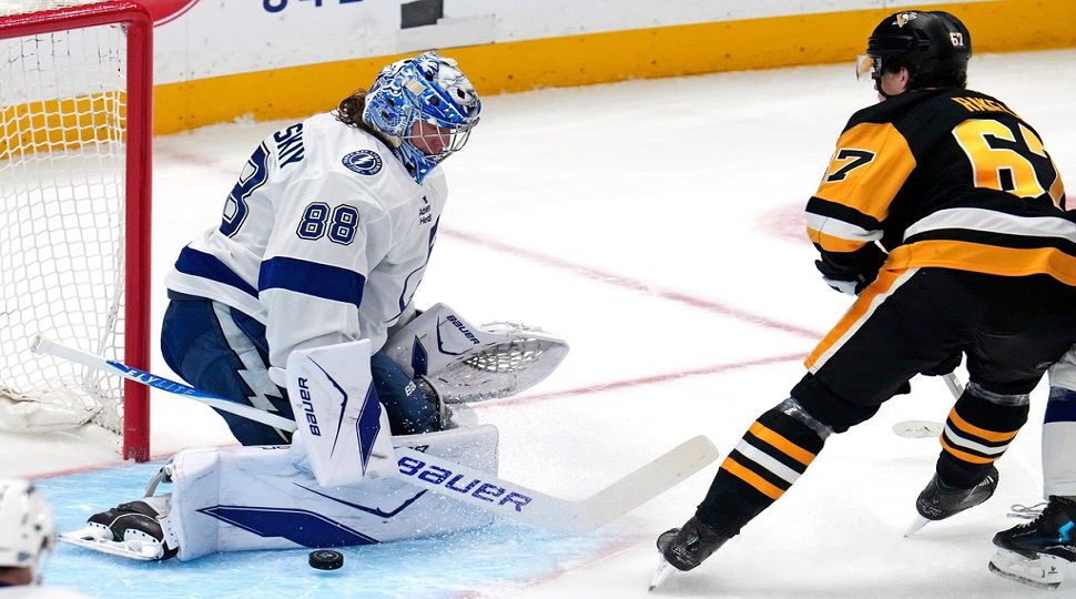 Tampa Bay Lightning goaltender Andrei Vasilevskiy (88) blocks a shot by Pittsburgh Penguins' Rickard Rakell during the first period of an NHL hockey game in Pittsburgh, Tuesday, Jan. 13, 2026. (AP Photo/Gene J. Puskar)